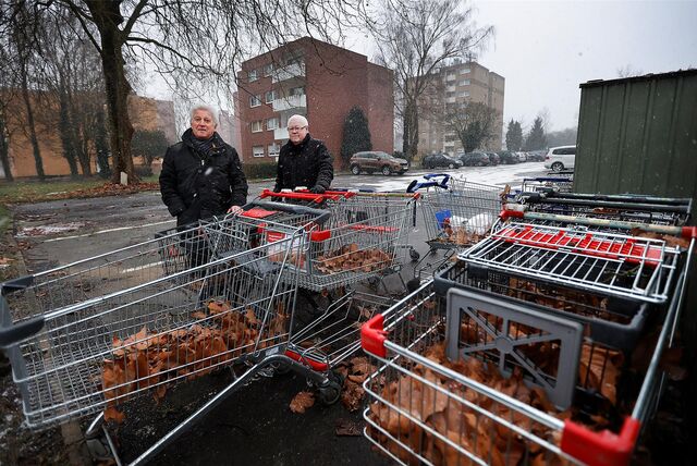 Peter Kunske (l.) und Horst Dinter vor der Schlange herrenloser Einkaufswagen. Wagen von Aldi, Rewe, Netto und Lidl sind im Wohngebiet Blumenstraße/Karl-Arnold-Straße zu finden.