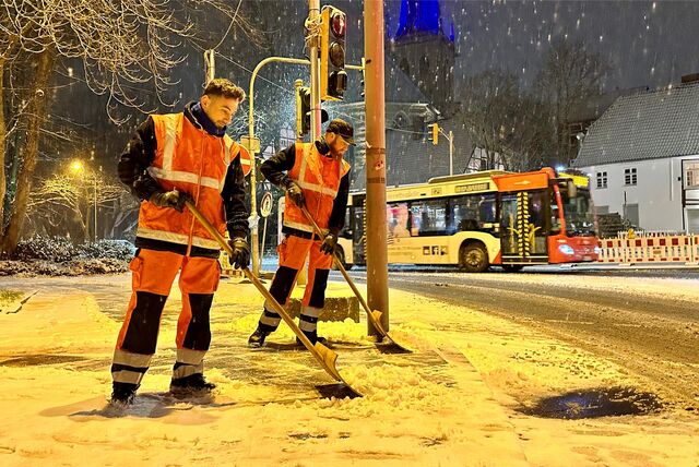 Zwei Mitarbeiter des Winterdienstes räumen eine Gehweg in Unna im Januar 2024 von Schnee frei.