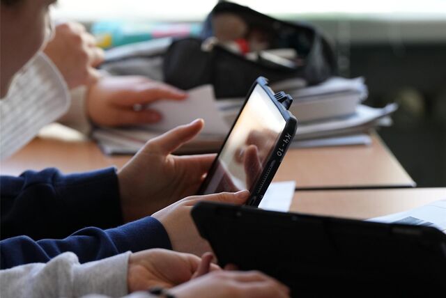 Kinder schauen auf Tablets.