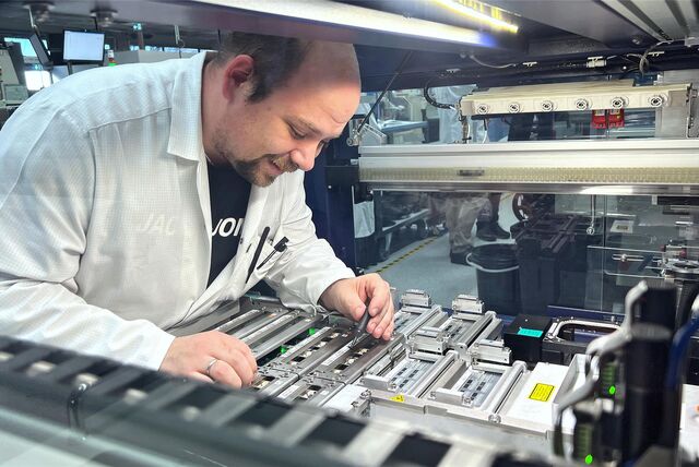 Einblick in die Produktion bei BTV im Indupark Unna: Tobias Mertens richtet eine Maschine ein, die in großer Stückzahl Mikrochips programmiert.