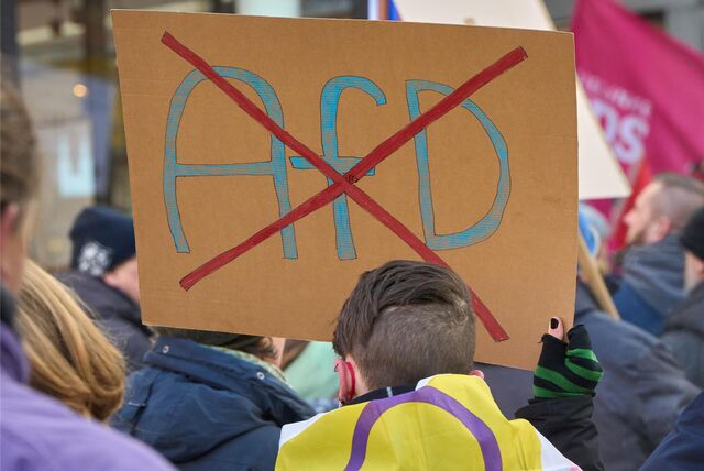 Ein durchgestrichenes AfD-Logo ist auf einem Schild bei einer Demo gegen Rechts zu sehen.