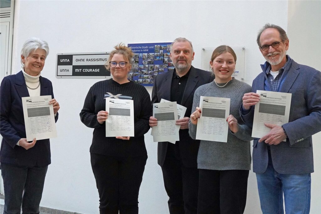 Fünf Personen stehen im Rathaus der Stadt Unna und zeigen Listen mit Unterschriften Fünf Personen stehen im Rathaus der Stadt Unna und zeigen Listen mit Unterschriften