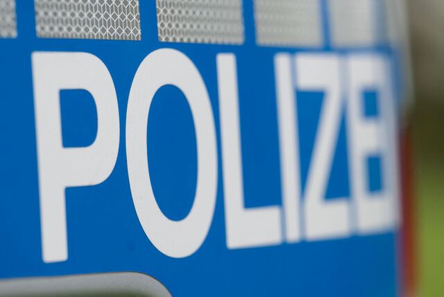 Nahaufnahme des „Polizei“-Schriftzuges auf einem Polizeiauto.