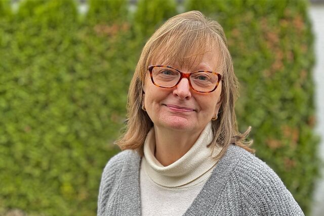 Dagmar Henn trägt eine Brille und schaut lächelnd in die Kamera