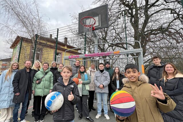 Zwei Kinder und eine Gruppe Erwachsene stehen vor einem neuen Fußballtor am Treffpunkt Villa in Holzwickede.