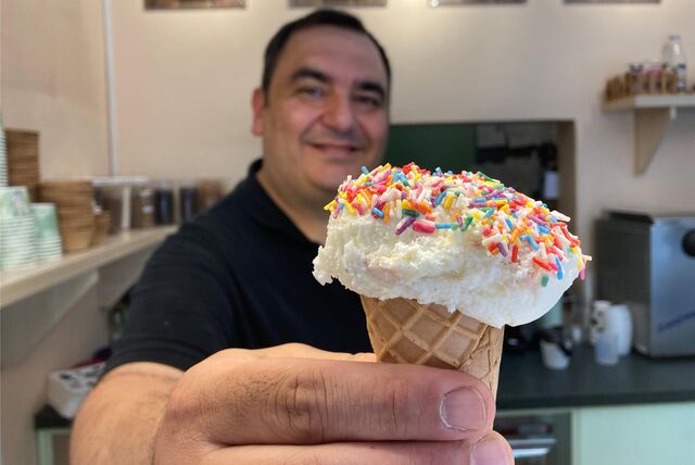 Hakan Köse aus Schwerte bietet bei „Bomonti Eis“ verschiedene Geschmackssorten an. Er hält eine Eiswaffel in die Kamera.