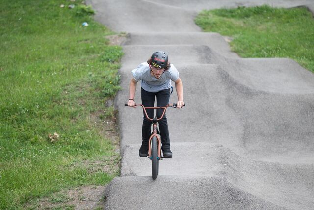 Ein Jugendlicher fährt mit seinem Rad durch einen Bikepark.