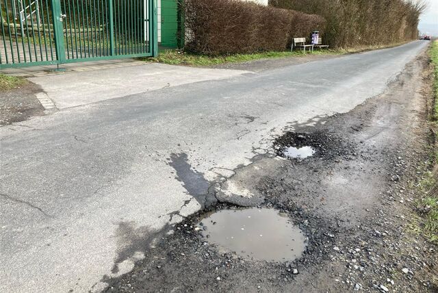 Am Wasserturm befinden sich direkt neben der asphaltierten Straße gleich zwei Schlaglöcher.