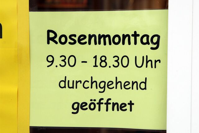 Im Schaufenster eines Geschäfts hängt ein Zettel mit einem Hinweis auf Öffnungszeiten am Rosenmontag