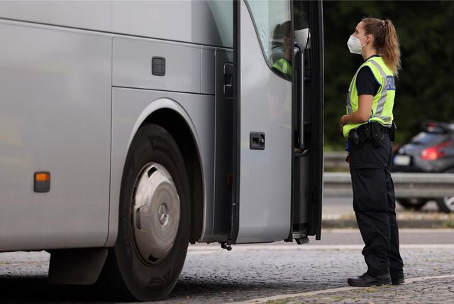 Polizistin steht an Reisebus.