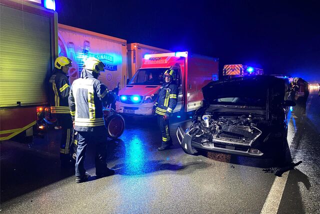 Rettungskräfte neben einem Auto, das bei dem Unfall auf der A52 schwer beschädigt wurde.