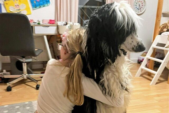 Olivia kuschelt mit Familienhund Freddy.