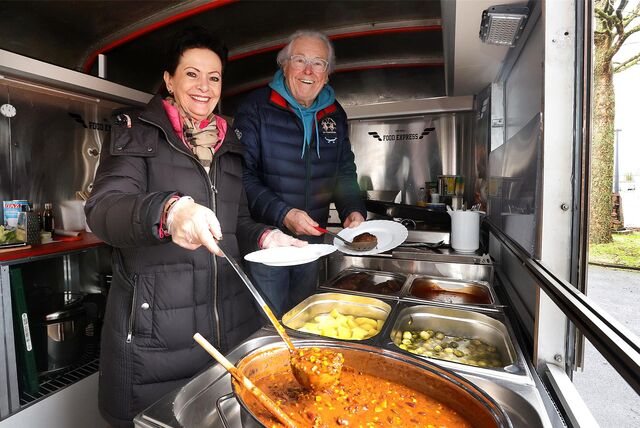 Dagmar und Dieter Neumann in ihrem Foodtruck vor einer Gulaschkanone.