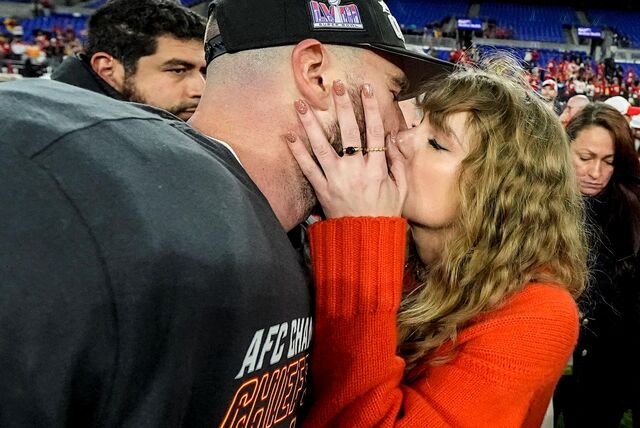 Die Musikerin Taylor Swift (r.) küsst Kansas-City-Chiefs-Tight-End Travis Kelce nach dem NFL-Footballspiel und dem Finaleinzug auf dem Spielfeld.
