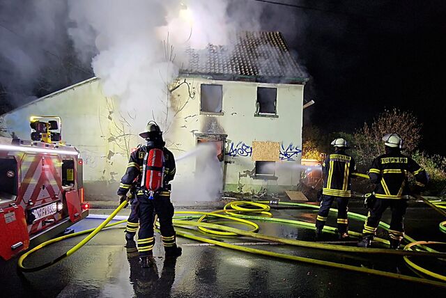 Dieses eigentlich leer stehende Wohnhaus hat in der Nacht zu Samstag (10.02.) in Flammen gestanden. Mehrere Feuerwehrleute löschen das Gebäude.