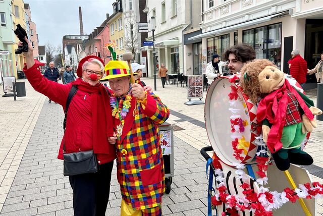 Auf dem Marktplatz in Unna steht der als Clown verkleidete Helmut Scherer. Er schlägt eine Pauke