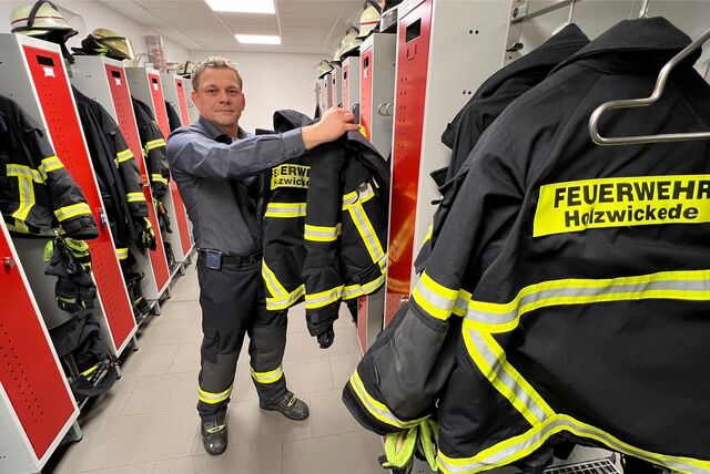 Enrico Birkenfeld, leitet die Holzwickeder Feuerwehr und legt sich in der Umkleide der Feuerwache seine Schutzkleidung an.