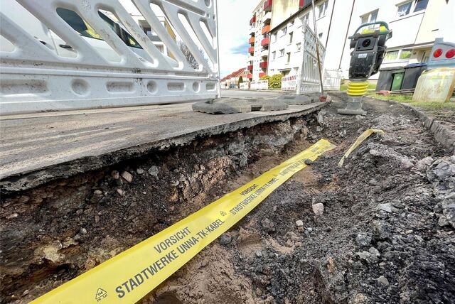 In einer Baugrube in Unna liegt ein Signalband mit der Aufschrift „Vorsicht Stadtwerke Unna TK-Kabel“. Hier wurde ein Glasfaserkabel verlegt.