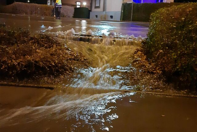 Wasser schießt von der Straße auf einen Radweg