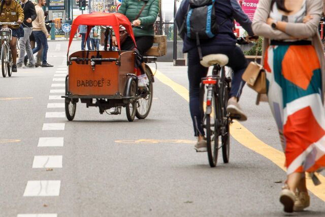 Auf einem Radweg sind ein Lastenfahrrad und ein Fahrrad unterwegs.