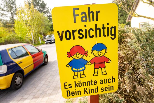 Zu sehen ist ein gelbes Schild mit der Aufschrift: Fahr vorsichtig, es könnte auch dein Kind sein.
