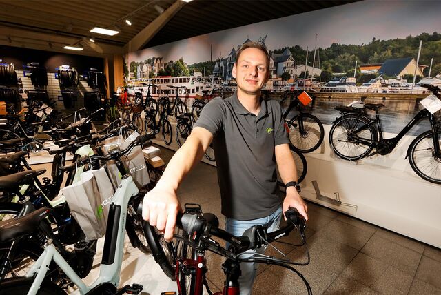 Daniel Robbert ist Storemanager bei AT Cycles in Bergkamen. Auf dem Bild sind außerdem Fahrräder zu sehen.