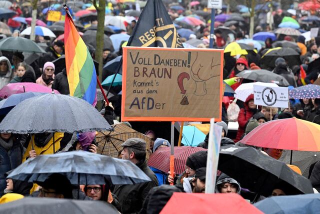 Menschen protestieren mit Plakaten gegen die AfD.