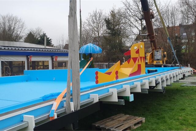 Ein komplettes Kinder-Schwimmbecken mit Schirmchen rollt langsam durch Dellwig: Der Schwertransport hat das Freibad erreicht.
