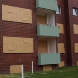 Die Fenster der geräumten Wohnungen an der Blumenstraße 8 sind weiterhin blind. Die massiven Holzplatten zeigen es deutlich an: Dieses Haus ist unbewohnbar.