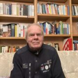 Prof. Dr. Friedrich Stallberg aus Waltrop sitzt in seinem Wohnzimmer auf einem Sofa vor einem Bücherregal.