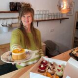 Konditormeisterin Anna-Lena Schultz hält eines ihrer Törtchen. Sie steht hinter der Theke in ihrem Café in Unna-Kessebüren.