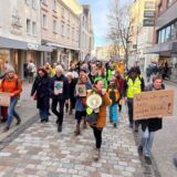 Bei einer Kundgebung für den Klimaschutz ziehen Menschen durch Unna, vorneweg Personen mit Plakaten und eine mit einem Megafon