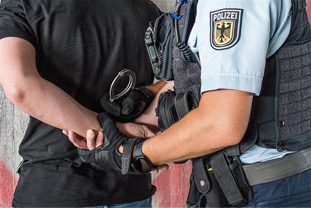 Mann bekommt Handschellen angelegt.