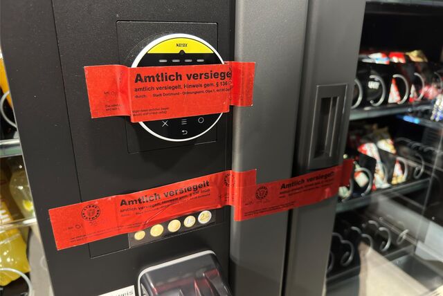 Ein rotes Siegel des Ordnungsamtes klebt an einem Kiosk-Automaten.