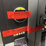 Ein rotes Siegel des Ordnungsamtes klebt an einem Kiosk-Automaten.