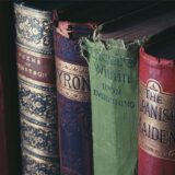 Historische Bücher stehen in einem Regal einer Bibliothek.