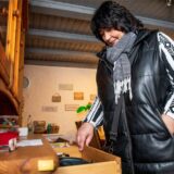 Nach der erneuten Einbruchsserie in einer Hertener Kleingartenablage sieht Sandra Metzner in den Schubladen eines hölzernen Vitrinen-Schrankes nach, ob etwas fehlt.