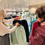 Eine Verkäuferin zeigt einer Kundin im Kaufhaus Schnückel in Bergkamen am verkaufsoffenen Sonntag zwei Pullover.