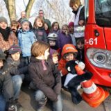 Kinder der Billmericher Liedbachschule in Unna hocken oder stehen während eines Bustrainings neben einem Linienbus der VKU