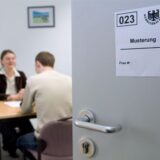 Claudia Wende, Leiterin der Betreuungsgruppe im Wehrersatzamt, erklärt einem Wehrpflichtigen in einem Büro im Kreiswehrersatzamt in Münster den Musterungsbescheid,