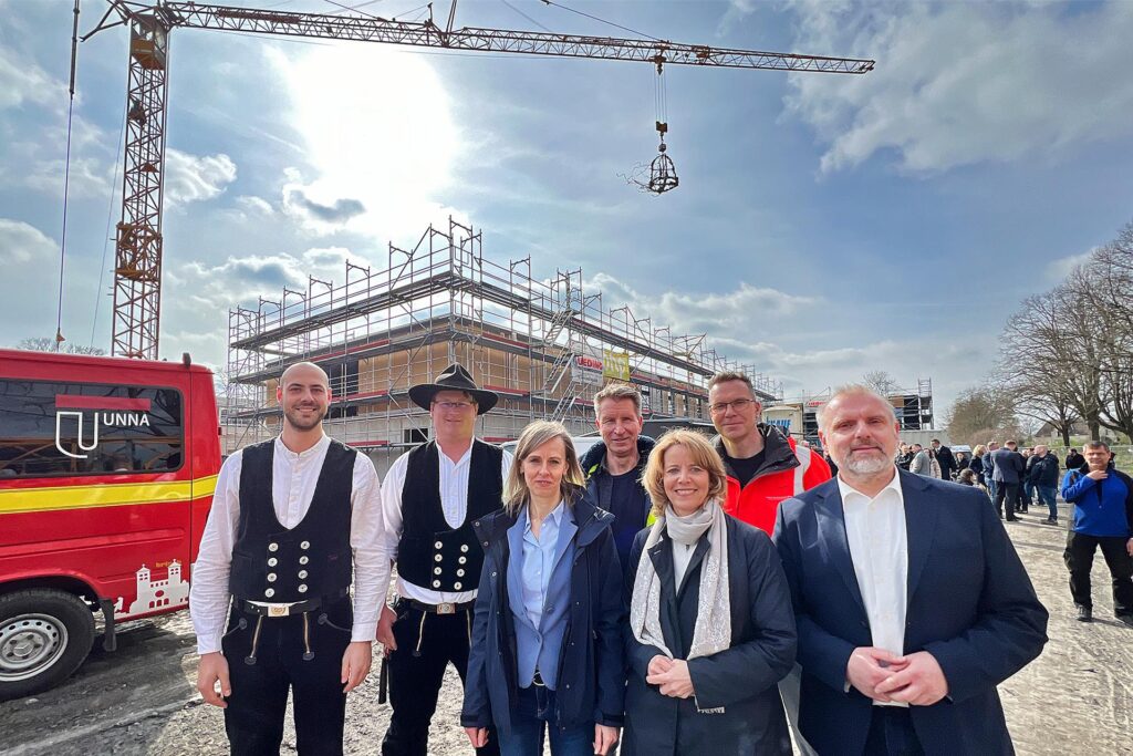 Die Hauptverantwortlichen für den Neubau stellten sich zum Gruppenfoto auf. Im Hintergrund hängt der traditionelle Richtkranz Die Hauptverantwortlichen für den Neubau stellten sich zum Gruppenfoto auf. Im Hintergrund hängt der traditionelle Richtkranz