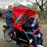 Niklas Klaverkamp testet den Komfort einer E-Rikscha und lässt sich von Martin Frenke fahren.