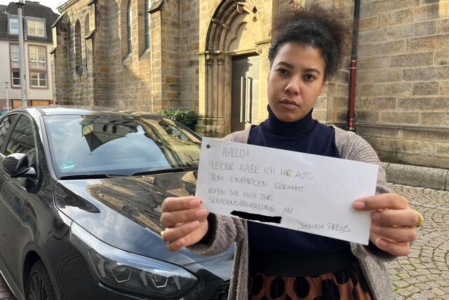 Reporterin Janina Preuß hält einen Zettel in die Kamera, auf dem steht: „Hallo! Leider habe ich beim Parken ihr Auto gerammt. Rufen sie mich zur Schadensabwicklung ab.“
