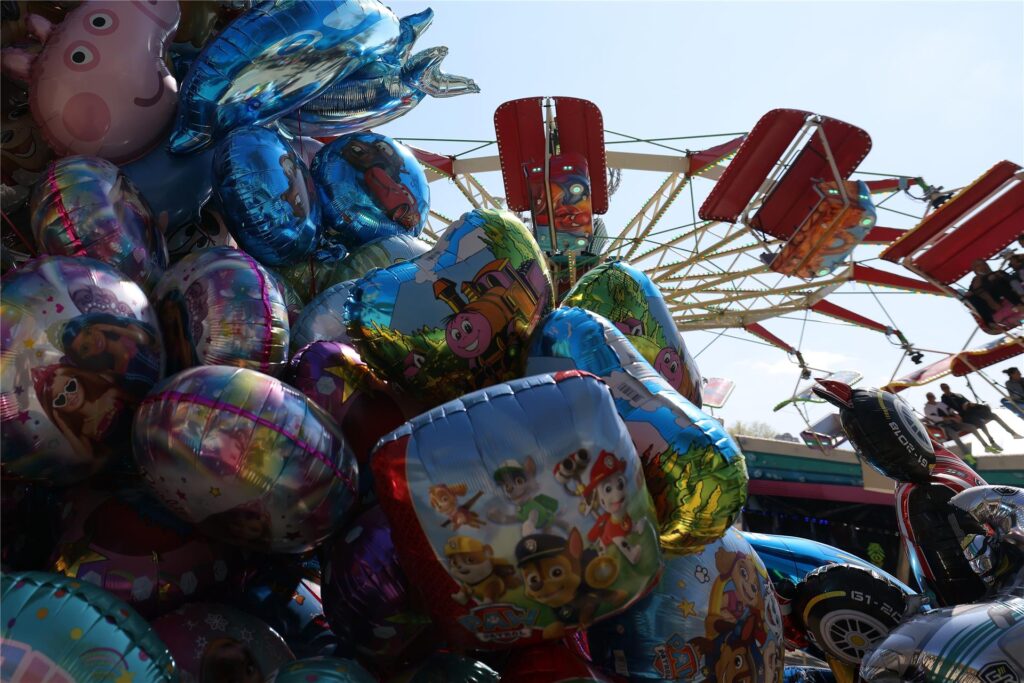 Mit Helium befüllte bunte Ballons sind auf der Osterkirmes in Düsseldorf-Grafenberg vor einem Fahrgeschäft zu sehen. Mit Helium befüllte bunte Ballons sind auf der Osterkirmes in Düsseldorf-Grafenberg vor einem Fahrgeschäft zu sehen.