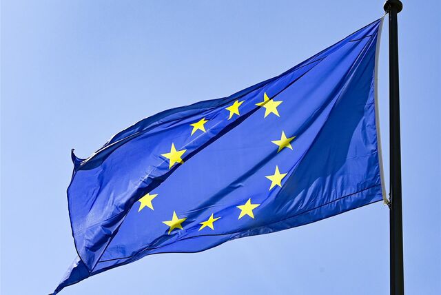 Eine Europaflagge weht vor blauem Himmel.
