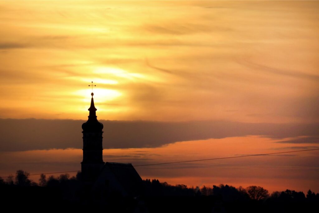 Hinter der Pfarrkirche St. Dionysius geht am Morgen die Sonne auf und beleuchtet dabei auch den Saharastaub, der in der Luft liegt. Hinter der Pfarrkirche St. Dionysius geht am Morgen die Sonne auf und beleuchtet dabei auch den Saharastaub, der in der Luft liegt.