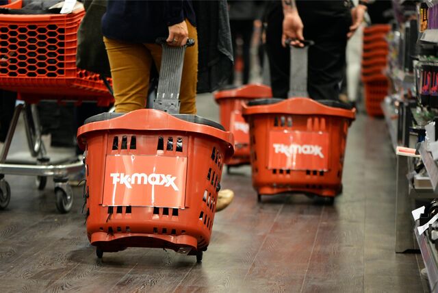 Menschen mit Einkaufskörben kaufen bei TK Maxx ein.
