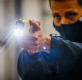 Polizist schießt einen Taser ab.