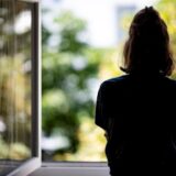 Ein Mädchen schaut aus einem Fenster. Symbolfoto für das Thema Opfer sexueller Straftaten