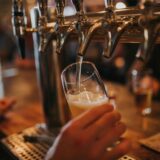 Eine Zapfanlage in einer Bar. Gerade wird ein Glas Bier gezapft.